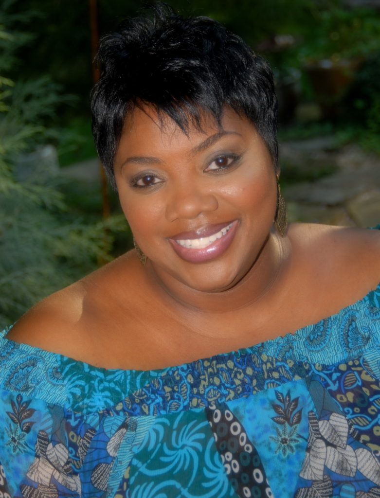 A woman with short hair wearing blue and white floral print.